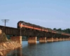 a diesel passenger train on a bridge crossing water