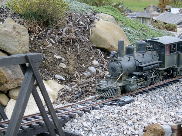 model train approaching bridge on garden railway