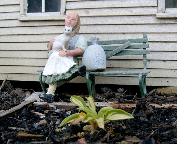 figure of woman on miniature bench