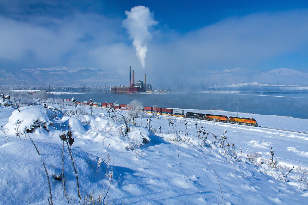 A distant shot of a train traveling through a snowy area