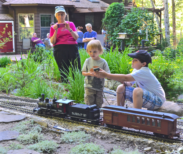 adult watching two children on garden railway