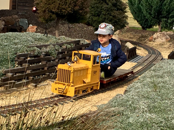 boy driving a ride-on locomotive