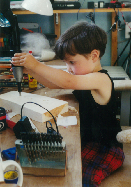 child using a cordless drill on a piece of wood
