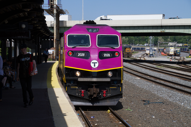Front view of purple and black commuter locomotive