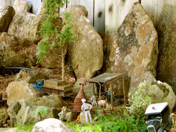 rocky scene with model wood house and figures
