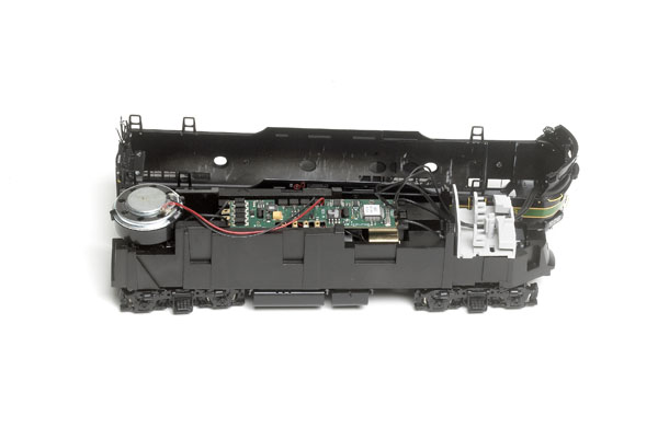 The SoundTraxx Tsunami DCC sound decoder is mounted on top of the die-cast metal frame. The speaker rests on top of the rear of the frame.