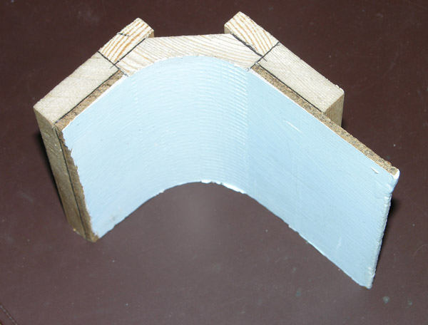 Flemming used a wide, softwood, cove molding in the corner that supported by trim strips so it matches the thickness of the backdrop.