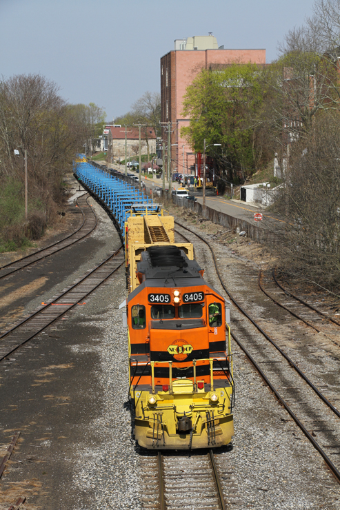 Orange diesel locomotive pulling long, blue freight train