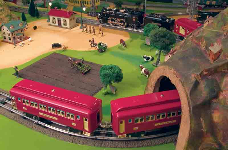 red train entering model tunnel