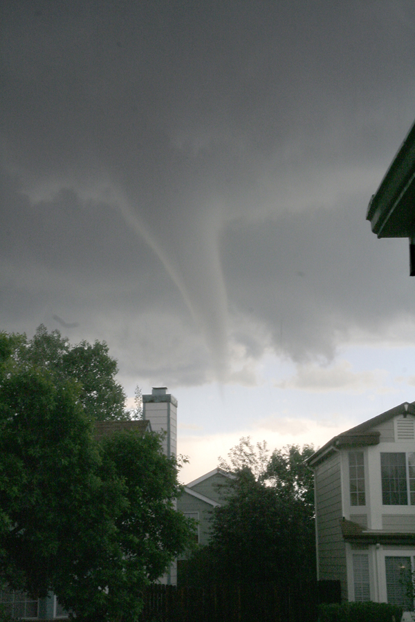 funnel cloud in the sky with houses nearby
