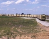 Coal train of yellow hoppers in open field