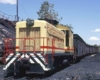 Yellow diesel switcher locomotive surrounded by coal