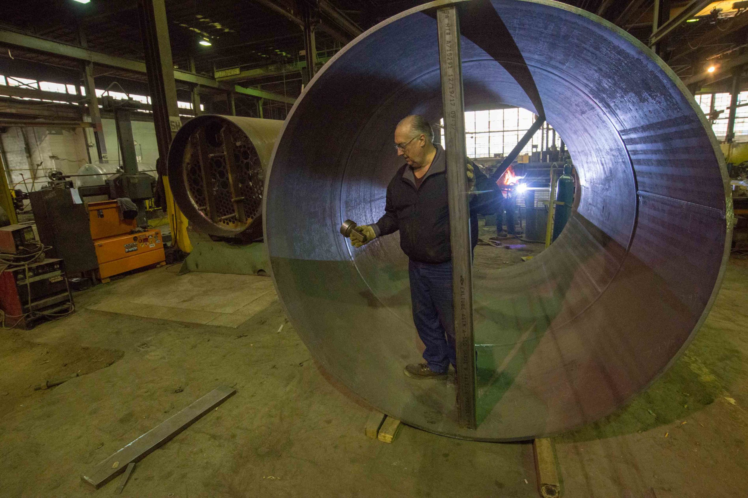 Man standing in large steel tube