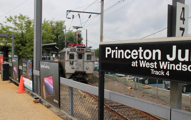 Electric-powered train arrives at passenger station platform