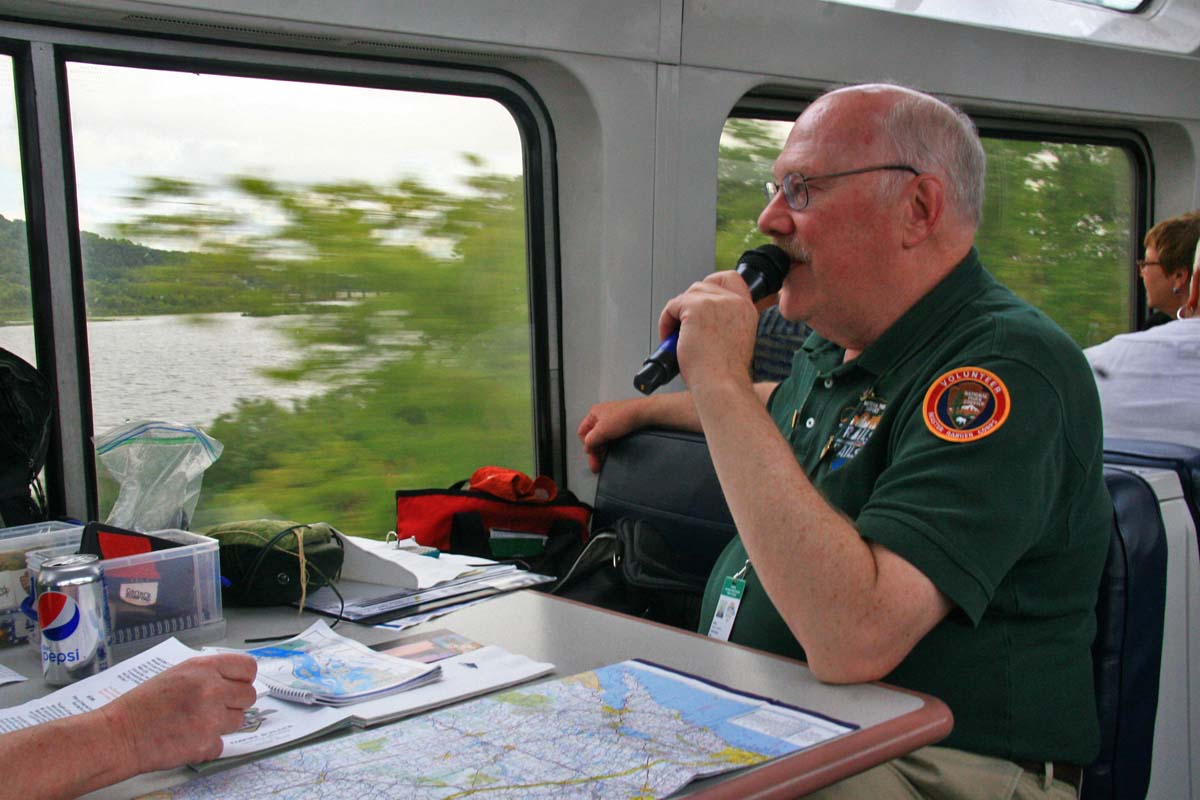 Man speaking into microphone on train