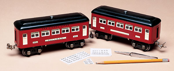 two model train cars with decals and a pencil