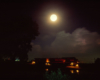 A train passing below a full moon