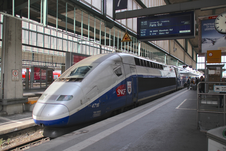 Blue and silver high speed train at station.