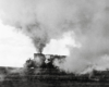 A distant shot of Big Boy passing by with big white smoke coming out of its chimney