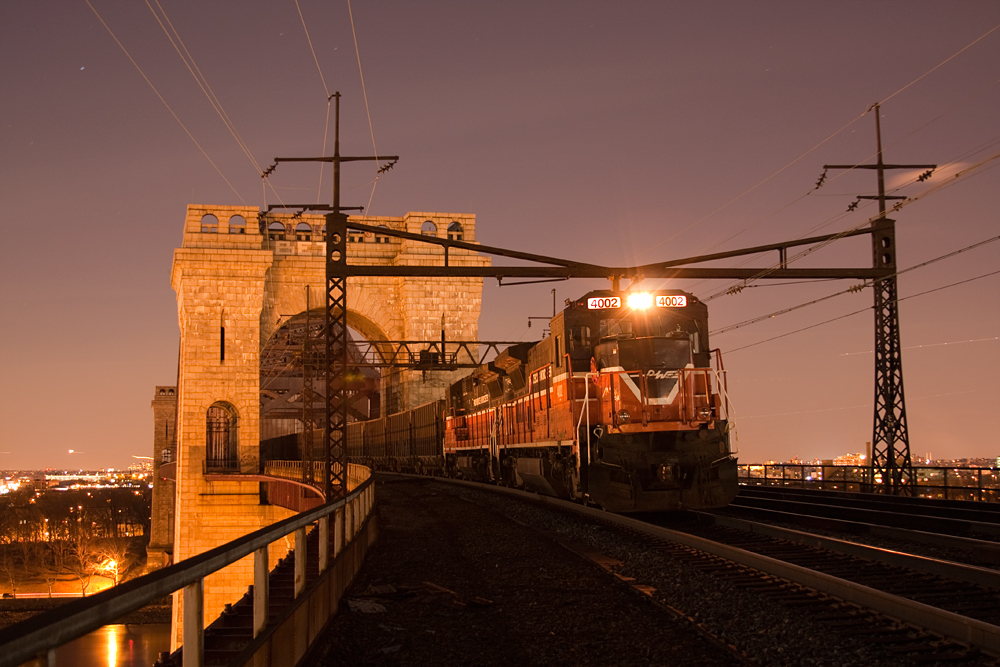 Freight train crosses bridge in the evening.