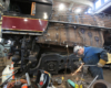 An employee working on a part of a train inside a factory