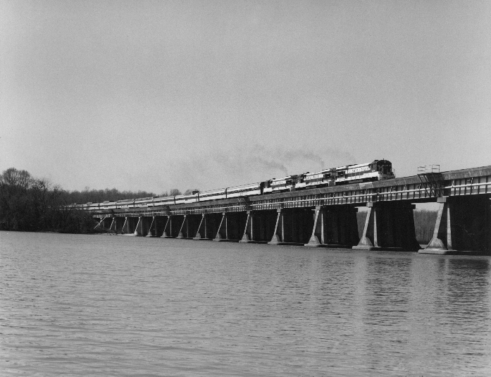 black and white photo of auto train on bridge