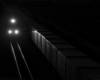 A train traveling in the dark with three headlights