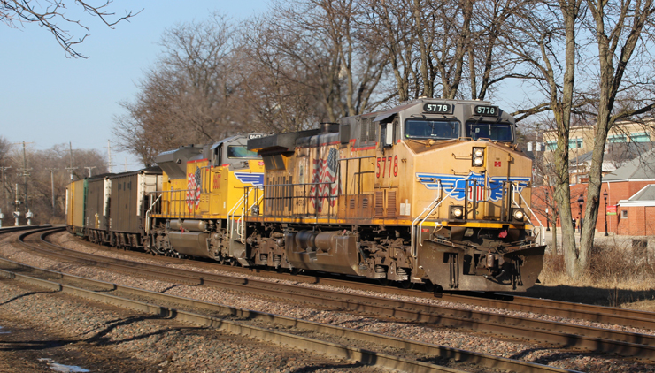 Two yellow locomotives on curve with coal train