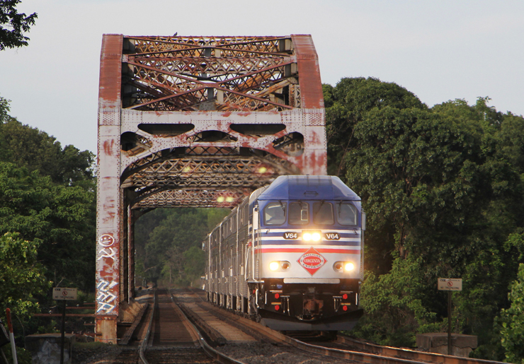 Commuter train crosses steel girder bridge