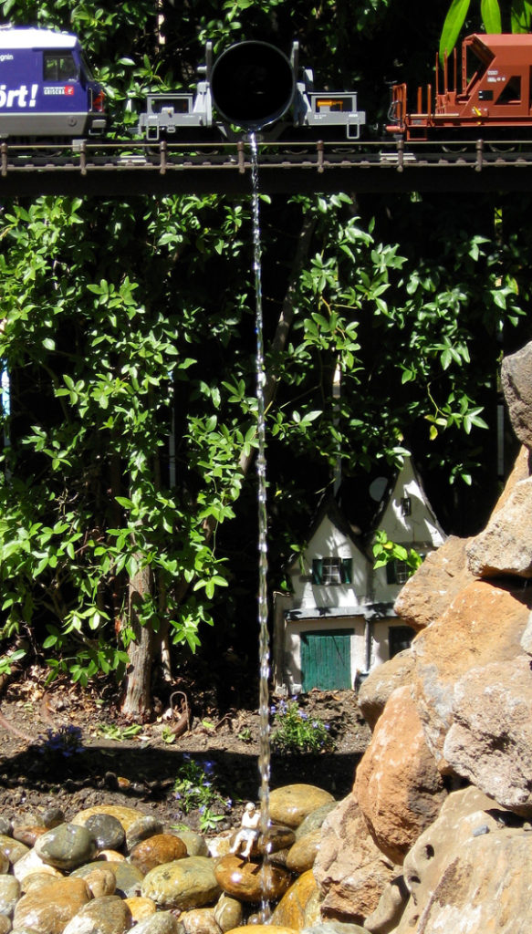 stream of water near rocks on garden railway