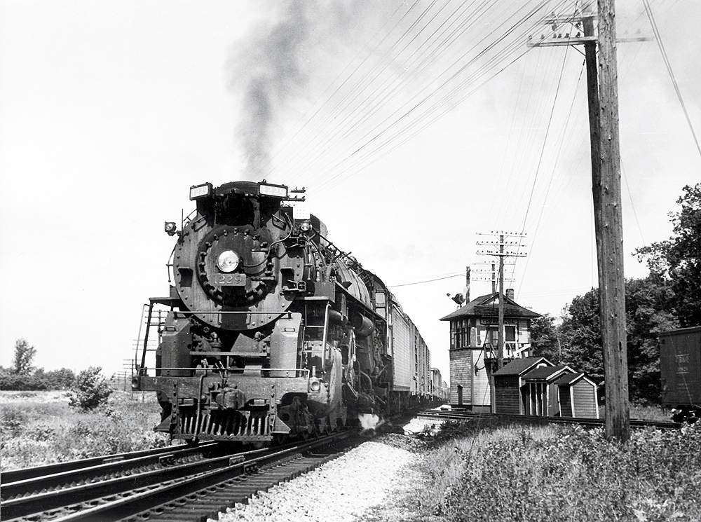 At 9:50 a.m. June 24, 1950, at the old Trowbridge Tower in East Lansing, Berkshire 1229 eases across the GTW diamonds and enters the siding to meet train 3, a Pere Marquette streamliner. 