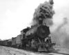 A black and white photo of 2-8-0 Consolidation 312 coming down the tracks with black smoke coming out of its chimney