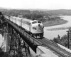 A black and white photo of F7 803 moving over a bridge