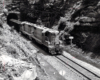 A black and white photo of GP7s 902 coming out of a tunnel