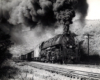 A black and white photo of locomotive 4-6-6-4 661 coming down the tracks with big black smoke coming out of its chimney