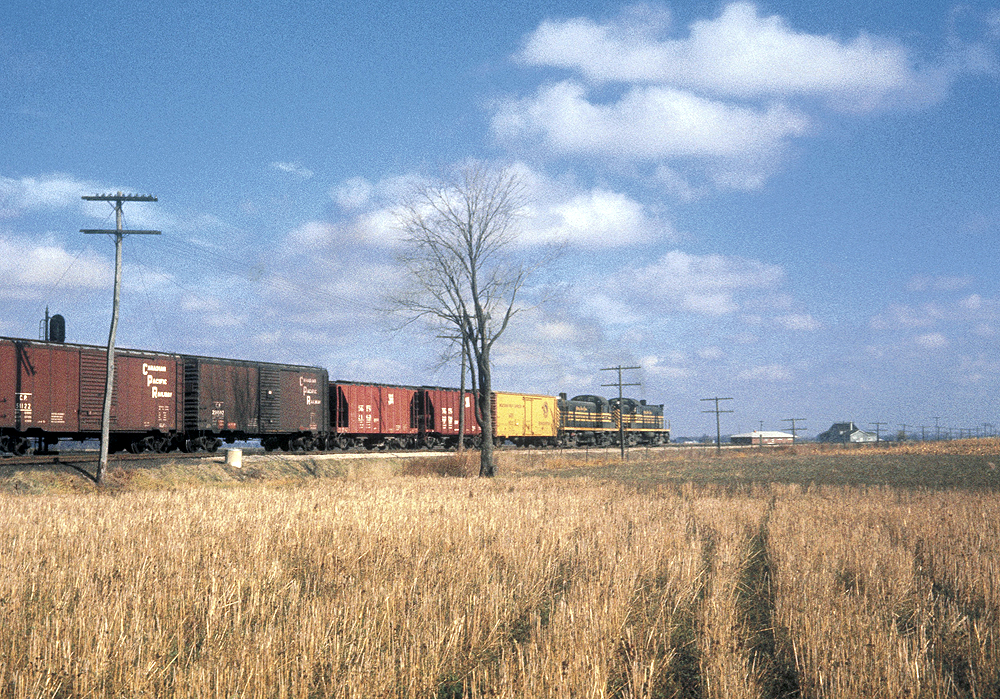 A distant shot of a train passing through farmland 