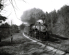 A black and white photo of Clinchfield 4-6-2 No. 154 passing by two people on the side of the tracks