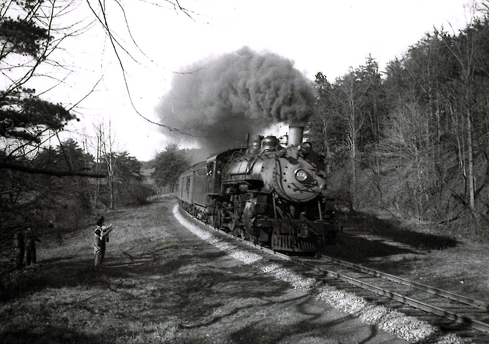 A black and white photo of Clinchfield 4-6-2 No. 154 passing by two people on the side of the tracks