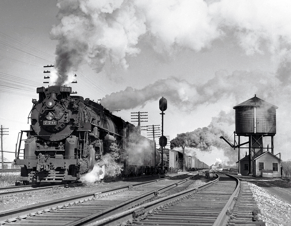 As an eastbound clears in the distance, Nickel Plate 779, Lima’s last 2-8-4, and a sister placed five cars back because of bridge weight restrictions, leave NH Tower near North East, Pa., in March 1957.