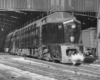 A black and white photo of a locomotive leaving a station