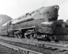 A close up black and white photo of a T1 4-4-4-4 high-speed passenger duplex sitting on the tracks