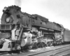 A close up black and white photo of a trains on the tracks