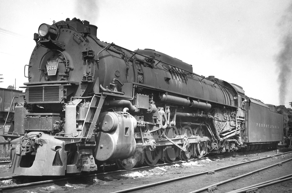A close up black and white photo of a trains on the tracks