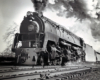 A close up black and white photo of a Q2 6187 locomotive coming own the tracks with big smoke coming out of its chimney