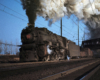 A M1 6917 steam locomotive coming down the trains with big white smoke coming out of its chimney