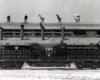 A black and white full length picture of a Lima-Hamilton 2,500 h.p. twin-engine transfer unit No. 8948 locomotive in front of a building