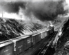 Captured from behind, a train passing below a stop light