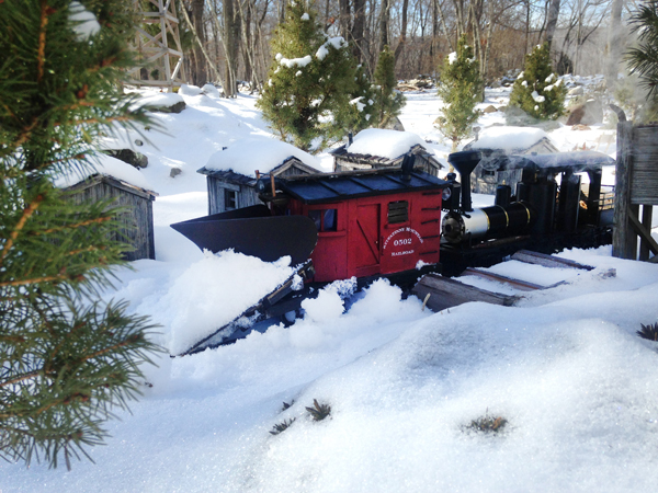 garden railroading in the winter: model train plowing snow