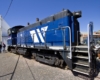 A blue train sitting outside a shop