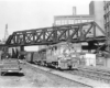 Two diesel locomotives on freight train under truss bridge